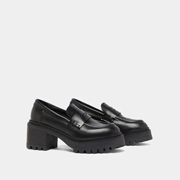 Heeled loafers with notched soles in black shiny leather