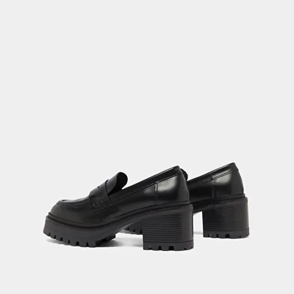 Heeled loafers with notched soles in black shiny leather